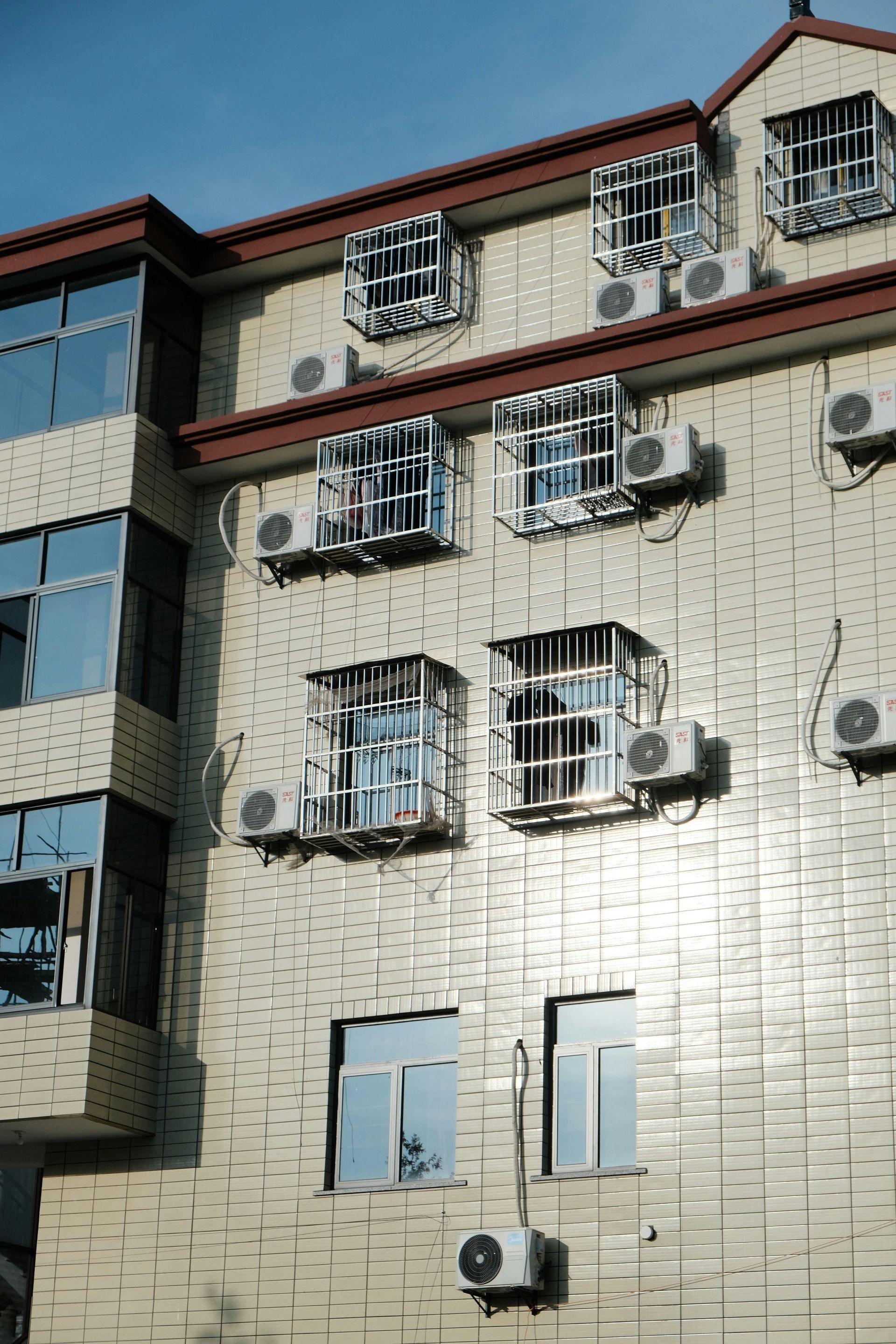 A building with a lot of windows and air conditioners